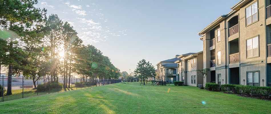 An apartment complex with a large yard that receives regular lawn and landscaping services in Roswell, GA.