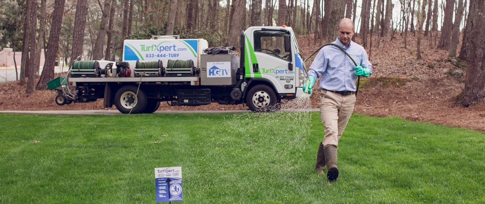 Professional applying lawn fertilizer to a lawn near Holly Springs, GA.