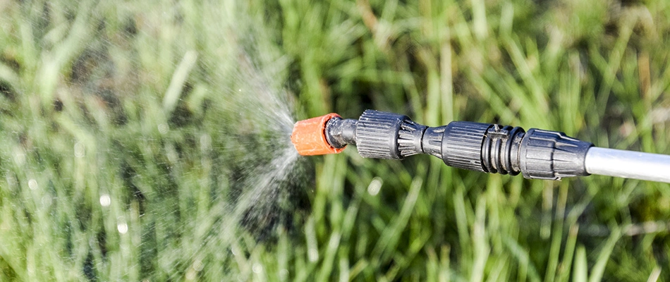 Nozzel spraying a lawn with weed control near Alpharetta, GA
