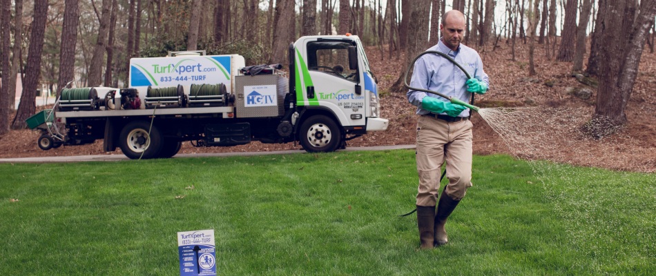 TurfXpert worker applying fertilizer treatment to lawn in Sugar Hill, GA.